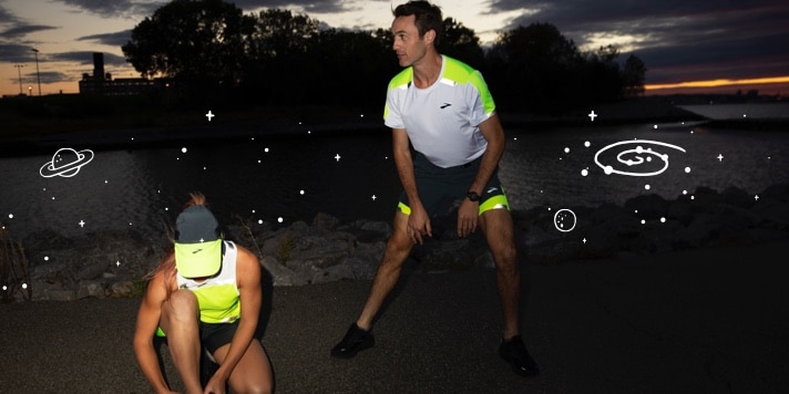 Due runner che fanno stretching nell’oscurità