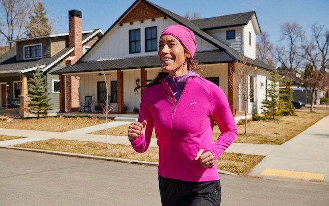Two runners wear multiple layers and apparel to prepare for a winter run.
