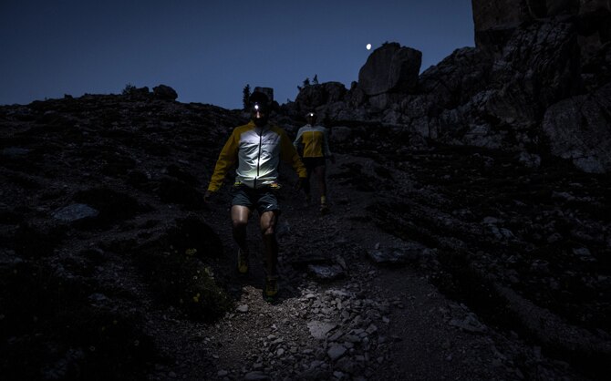 Trailrunners met koplampen die in het donker lopen