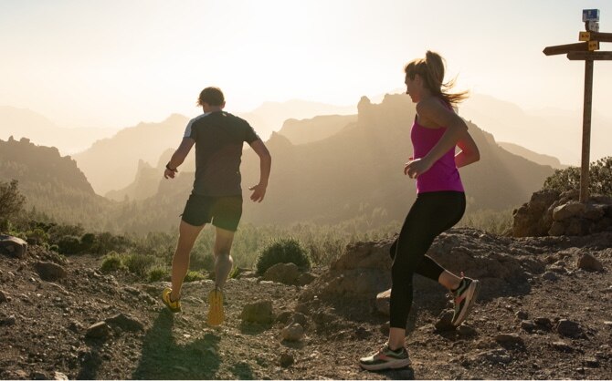 Two runners running in the mountains