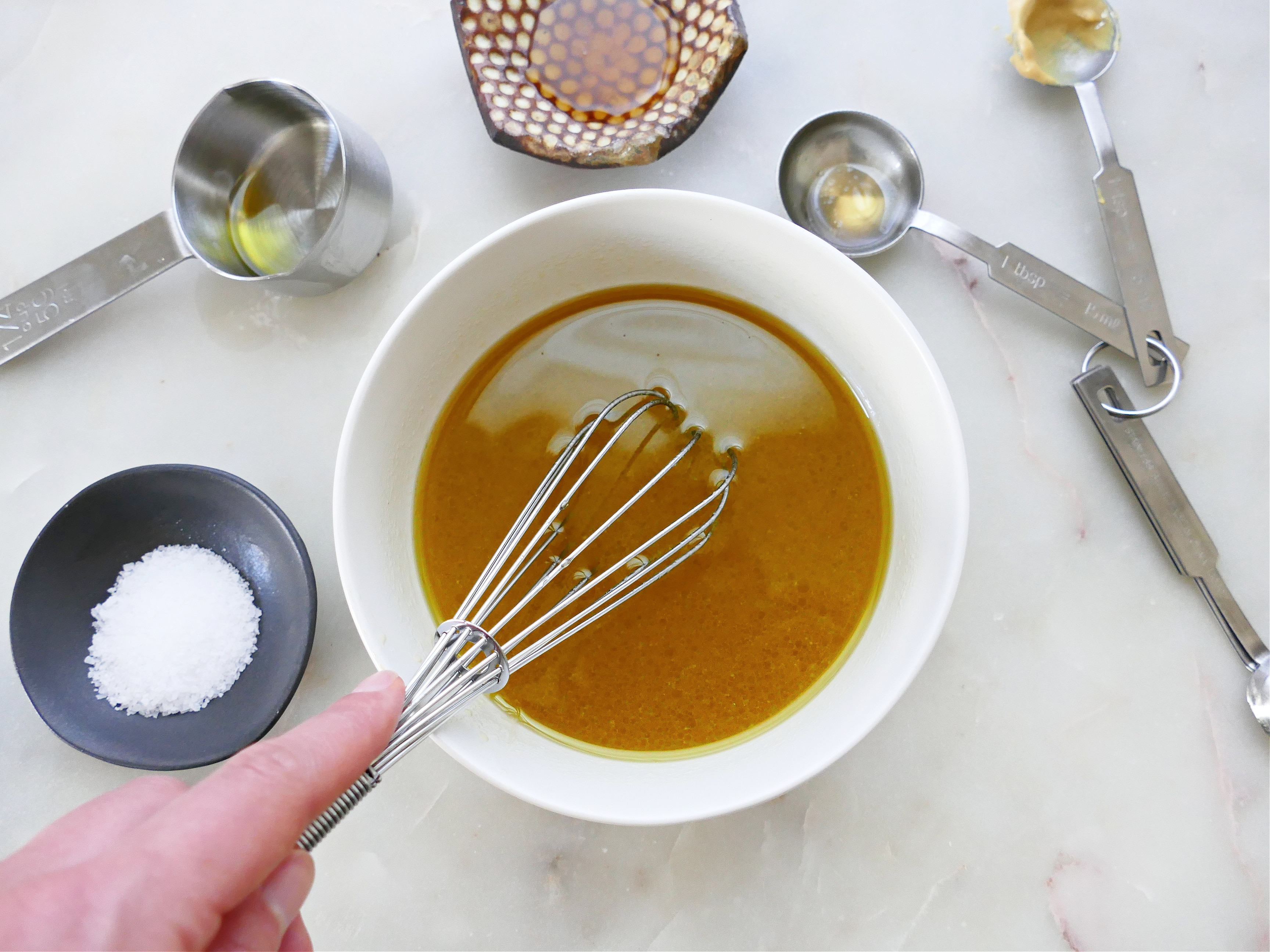 Un bol con salsa y unas varillas batidoras