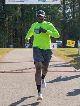 Una corredora cruzando la línea de meta de una maratón