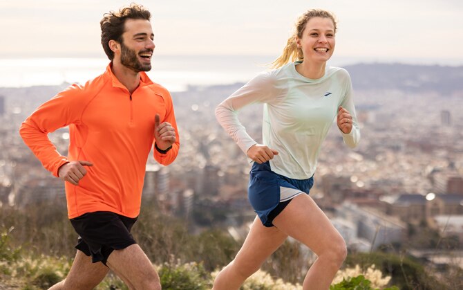 Two people running down a rocky trail.