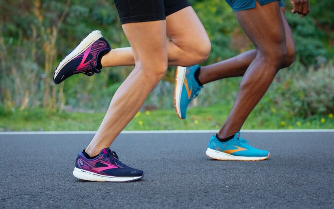 Two runners with their feet striking the ground