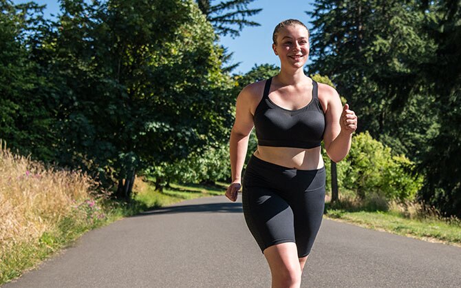 Women running on a paved trail in a Dare Racerback run bra