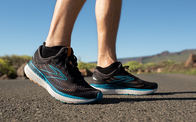 Two pairs of Brooks road-running shoes are placed side by side.