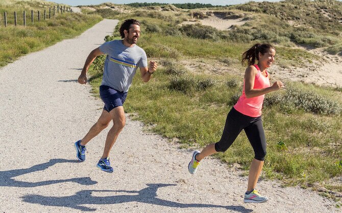 Two runners running down a trail.