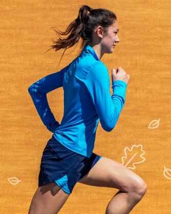 Woman running in a blue dash half zip