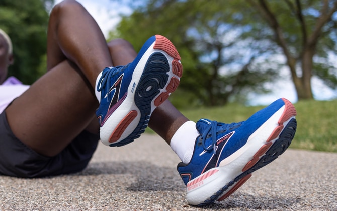 Runner sitting on concrete showing her running shoes