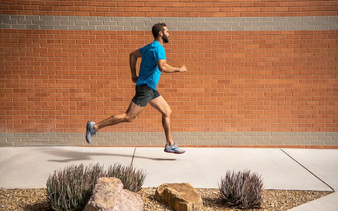 Man running by a brick wall