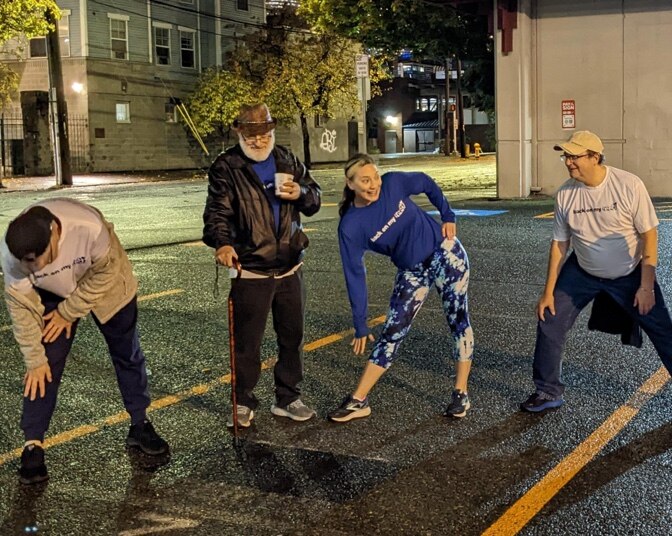 Joy Wilcox, directrice du territoire de la Côte Ouest de BoMF, s’étire avec des membres dans un cercle de Seattle