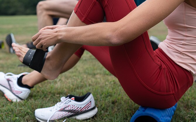 Women taping up her foot.