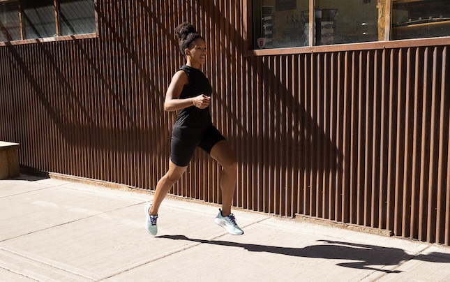 Side view of a runner next to a building.