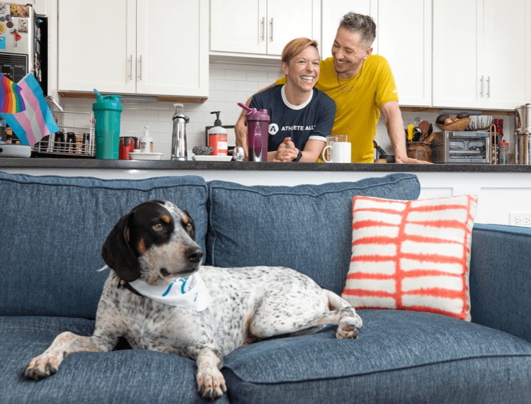 Un chien sur le canapé avec Anne et Shane en arrière-plan