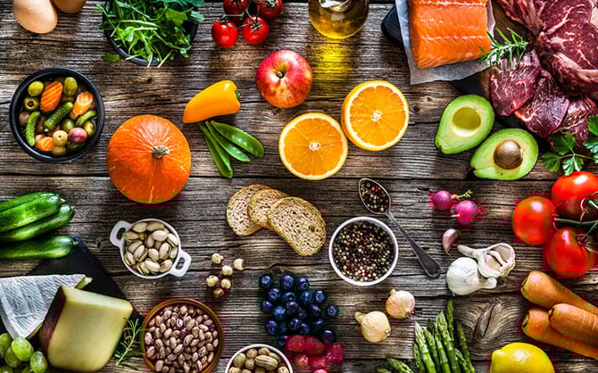 Una variedad de frutas, verduras y cereales esparcidos.