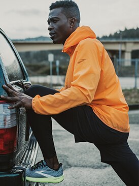 Runner stretching on a car