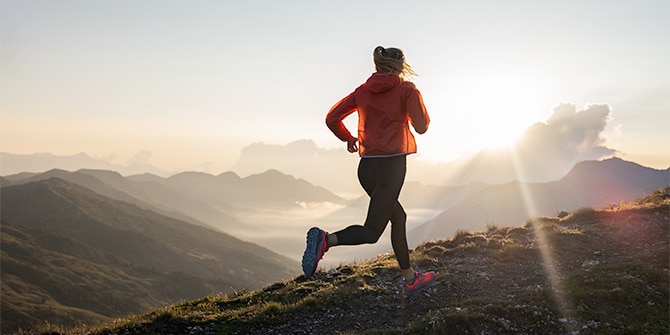 A runner on a trail at sunset