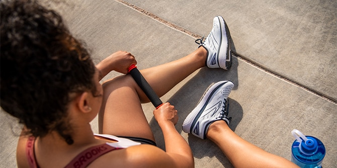 Woman sitting on the ground rolling her calf