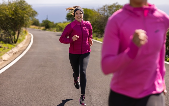 Two runners wear multiple layers and apparel to prepare for a winter run.