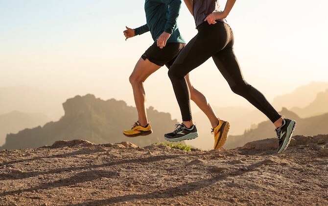 Two runners legs running over a rocky path