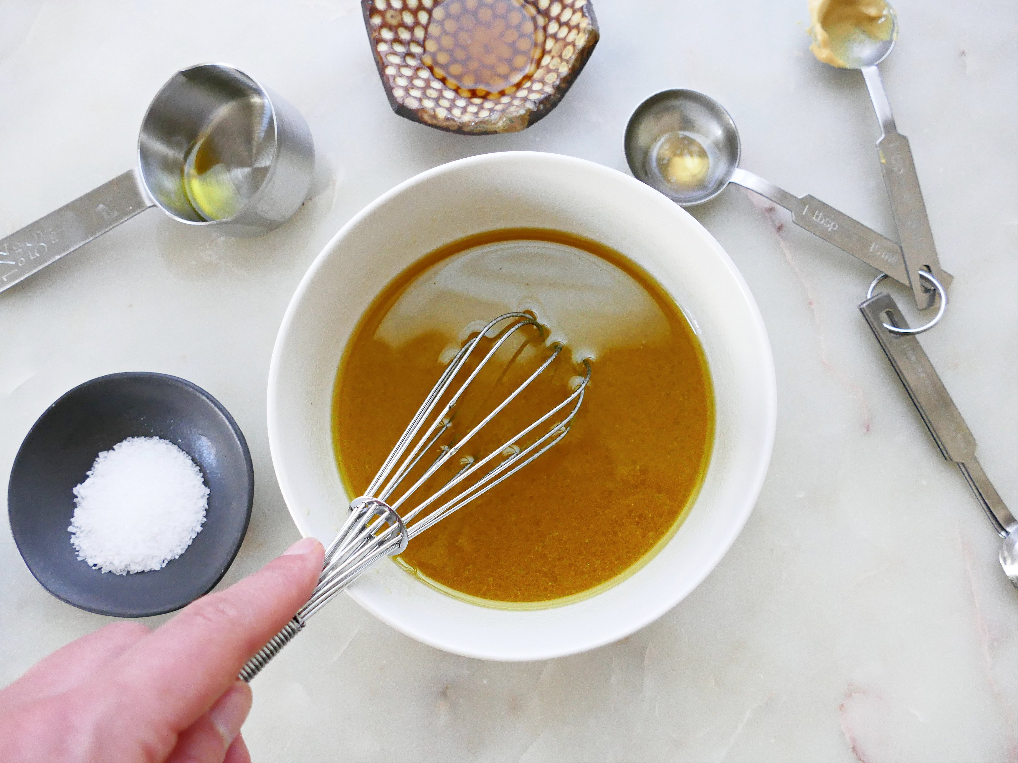 A bowl with sauce and a wisk