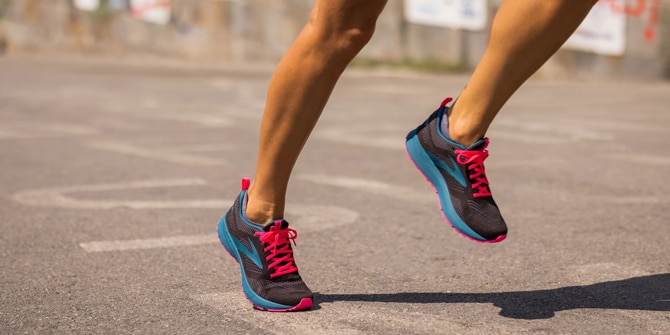 Closeup shot of a runner’s leg in a seated calf stretch position.
