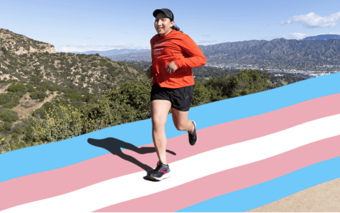 Un corredor en un sendero con la bandera transgénero con los colores del orgullo