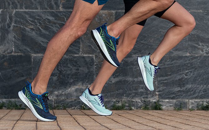 Two runners stride forward in unison