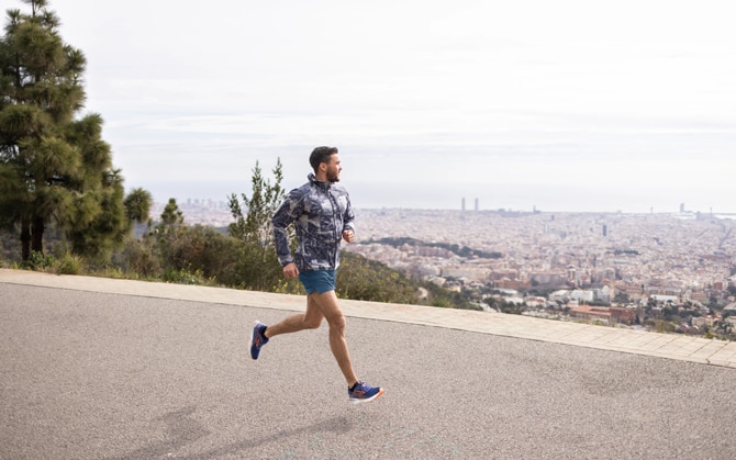 Man running on pavement overlooking city
