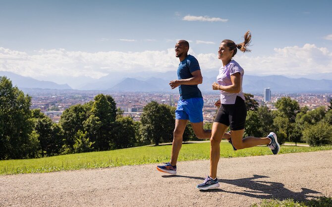 Deux runners profitant d’un jogging au soleil sur un chemin de terre.