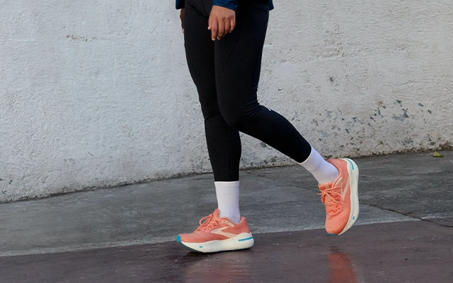 Image d’une femme marchant avec aux pieds une paire de Ghost Max corail