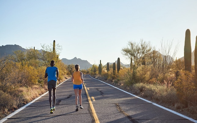 Runners on desert road