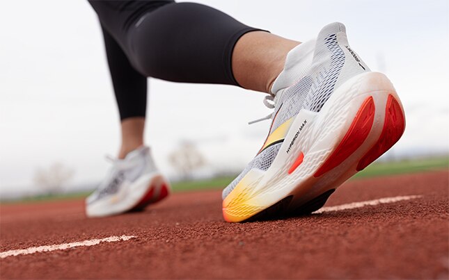 Plan en contre-plongée d’un runner en plein milieu d’une foulée.