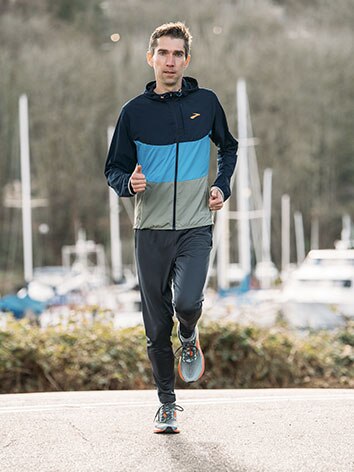 Runner running in Brooks Canopy Jacket and shoes
