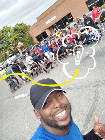 Un homme prend un égoportrait avec un groupe de coureurs