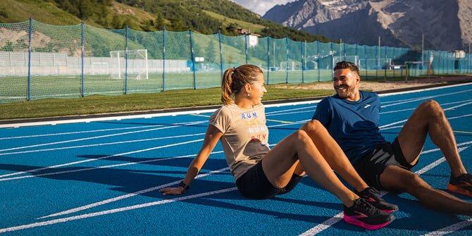 Two runners sitting on a track