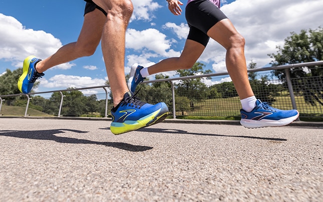 Jambes de deux runners en train de courir sur du bitume
