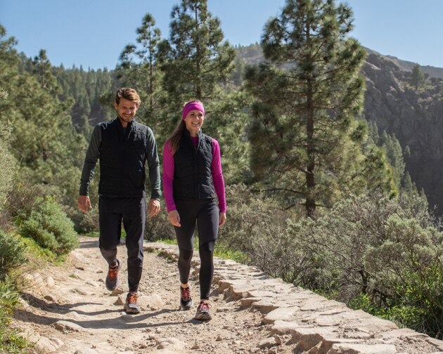 Ein Mann und eine Frau gehen nebeneinander auf einem Trail