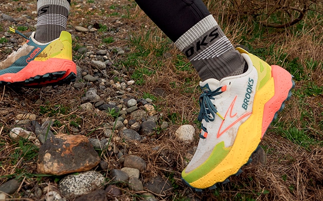 a person running on a rocky trail in the Brooks Caldera 8 trail running shoes