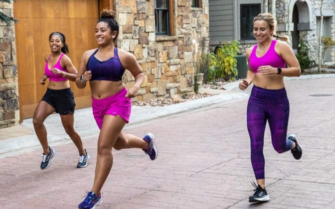 Tre runner in reggiseni da running rosa e viola