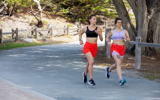 Deux femmes courent sur un chemin pavé