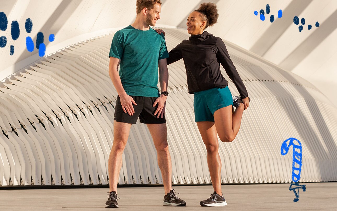A man and woman in conversation stretch and prepare for a run.