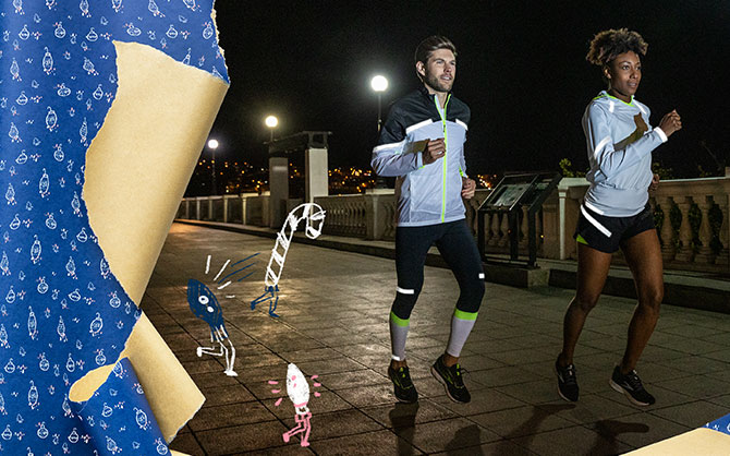 Un homme et une femme portant des vêtements réfléchissants Brooks Run Visible courent le soir.