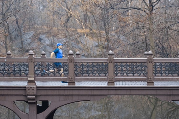 AJ running across a bridge
