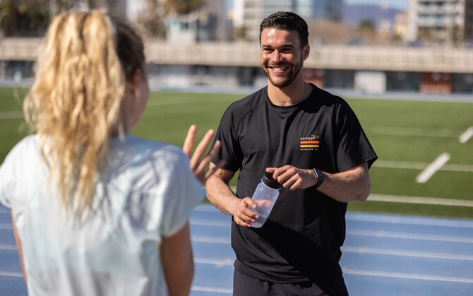 Two runners chatting on a track