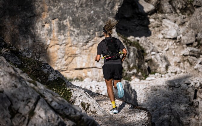 Trailrunner die op de rand van een berg loopt