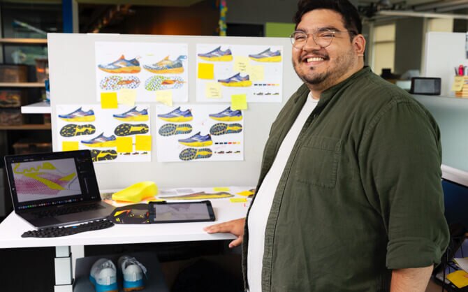 Man standing in front a desk with shoe designs