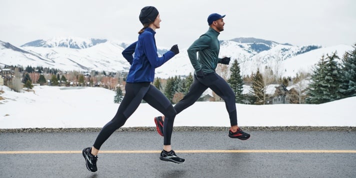 Two runners walking running on a snowy street