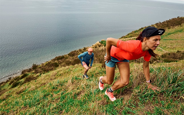 two people trail running up a hill in the Brooks Catamount 4 trail running shoes