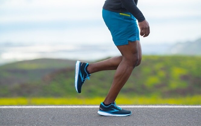 Close up view of a runner wearing a pair of long-distance running shoes.